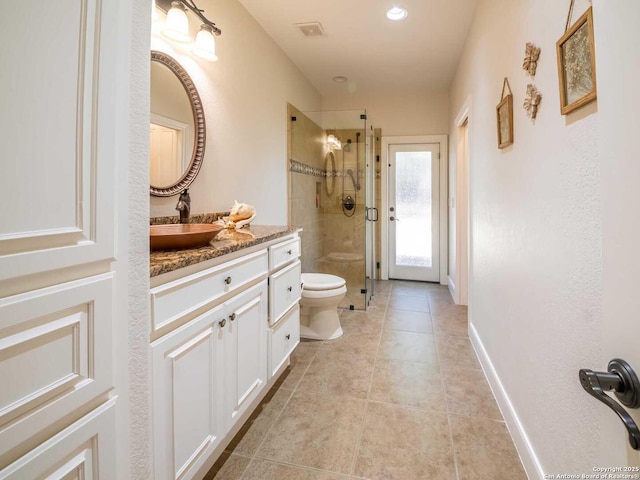 bathroom with tile patterned flooring, vanity, an enclosed shower, and toilet