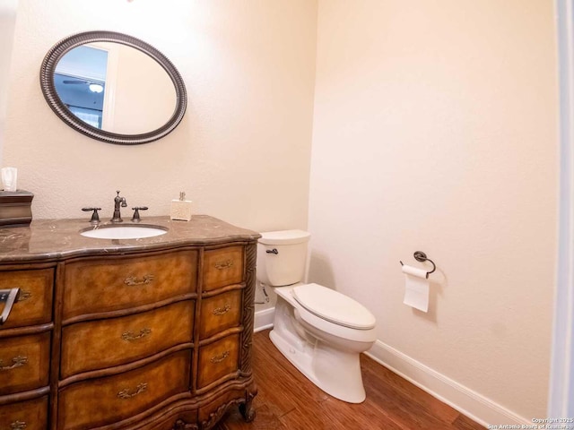 bathroom featuring vanity, hardwood / wood-style floors, and toilet