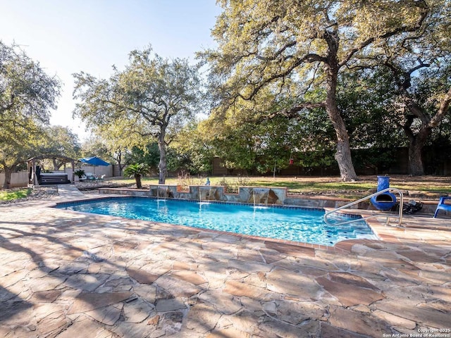 view of pool with a patio and pool water feature