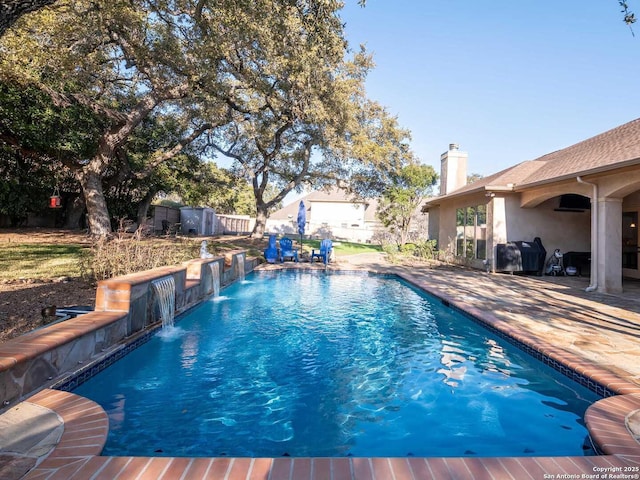 view of swimming pool featuring pool water feature and a patio area