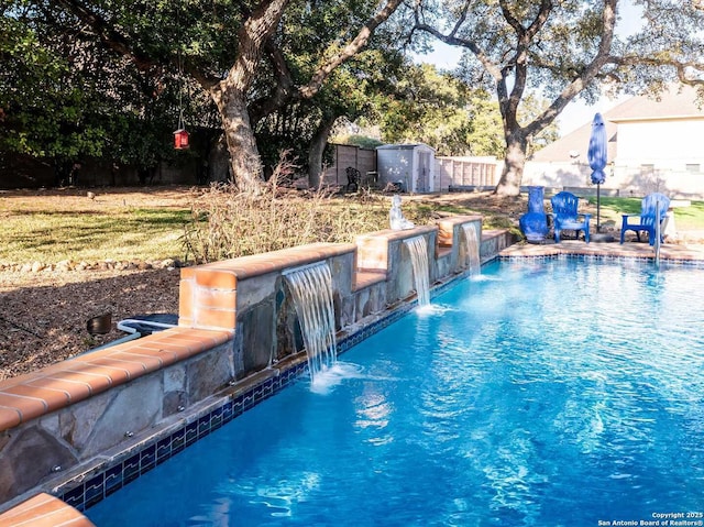 view of pool featuring pool water feature and a storage unit