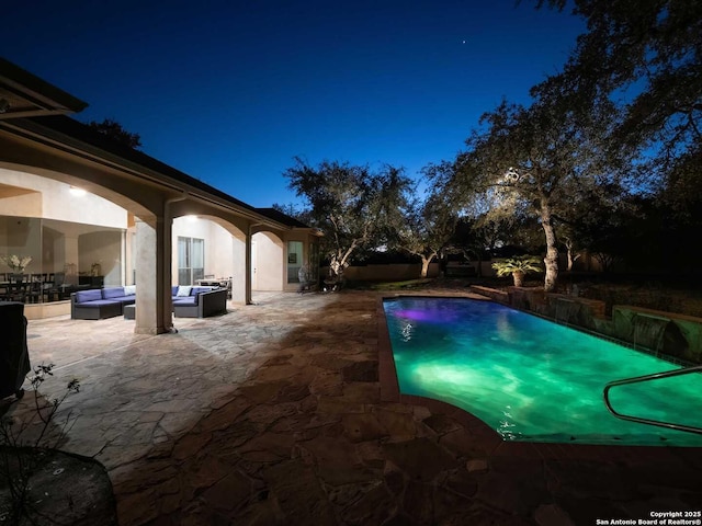 pool at twilight with an outdoor living space and a patio area