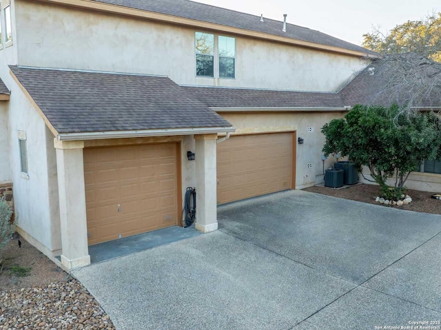 view of front of home with a garage and central air condition unit