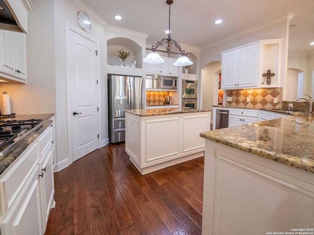 kitchen featuring pendant lighting, appliances with stainless steel finishes, sink, and white cabinets