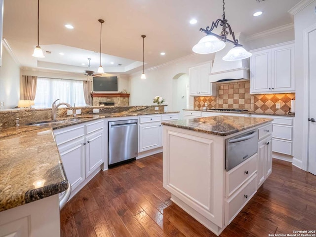 kitchen featuring white cabinetry, decorative light fixtures, stainless steel appliances, and a center island