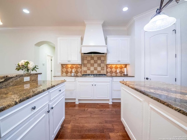 kitchen featuring hanging light fixtures, white cabinetry, custom range hood, and dark hardwood / wood-style floors