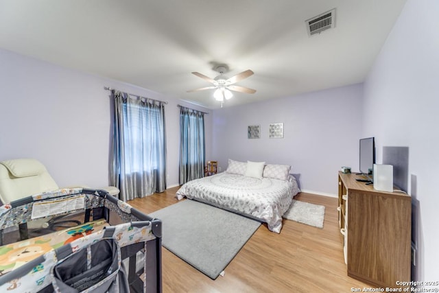 bedroom with light hardwood / wood-style flooring and ceiling fan