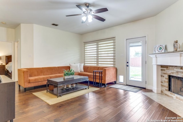 living room with ceiling fan, a fireplace, and hardwood / wood-style floors