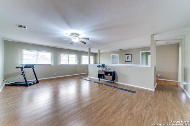 workout room with ceiling fan and light hardwood / wood-style flooring