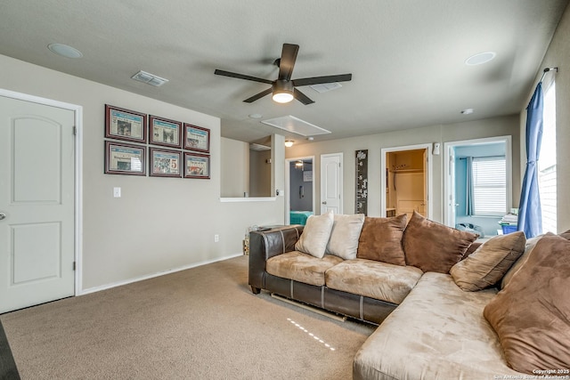 carpeted living room featuring a textured ceiling and ceiling fan