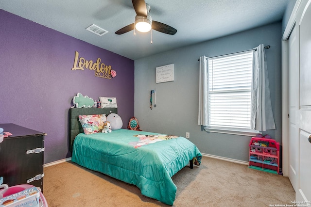 carpeted bedroom with ceiling fan and a closet