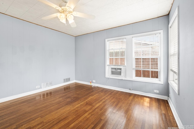 unfurnished room with wood-type flooring, cooling unit, visible vents, and a ceiling fan