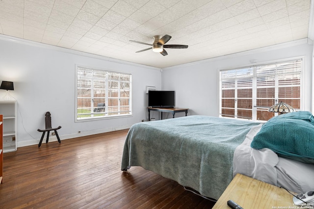 bedroom with a ceiling fan, baseboards, crown molding, and wood finished floors