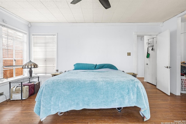 bedroom with ceiling fan, wood finished floors, and crown molding