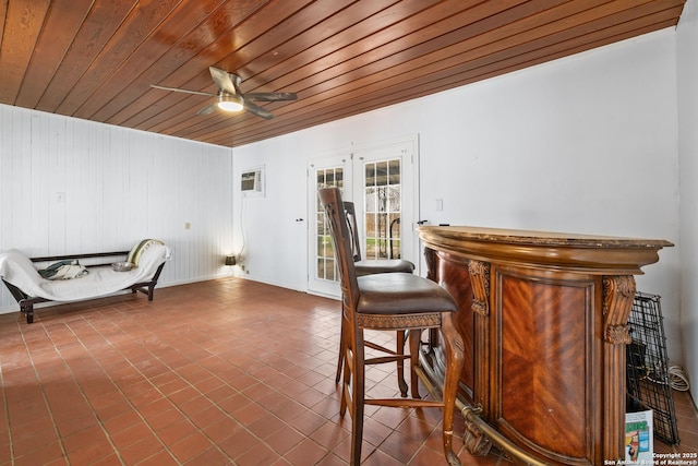 interior space featuring a dry bar, wood ceiling, an AC wall unit, ceiling fan, and tile patterned flooring