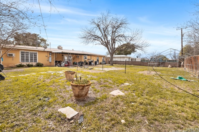 view of yard with a fenced backyard and a wall mounted AC