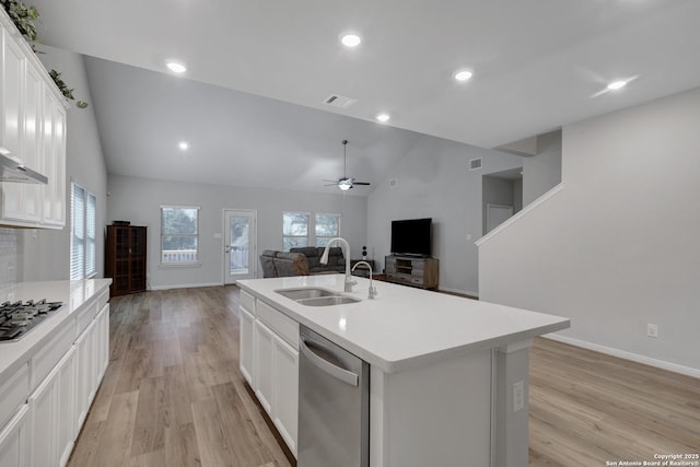 kitchen with sink, appliances with stainless steel finishes, light hardwood / wood-style floors, an island with sink, and white cabinets