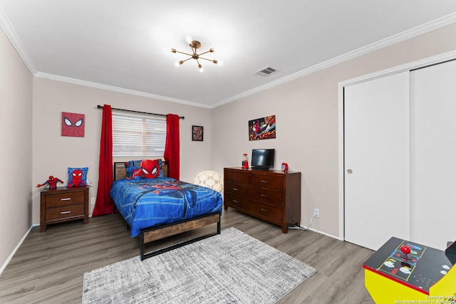 bedroom with a closet, ornamental molding, and light hardwood / wood-style flooring