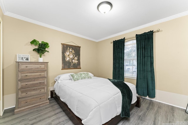 bedroom with ornamental molding and wood-type flooring