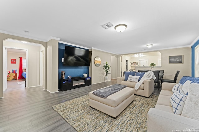 living room with wood-type flooring and crown molding