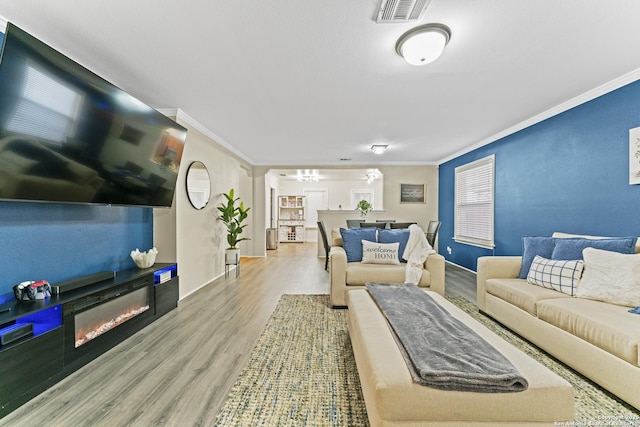 living room with crown molding and light hardwood / wood-style flooring