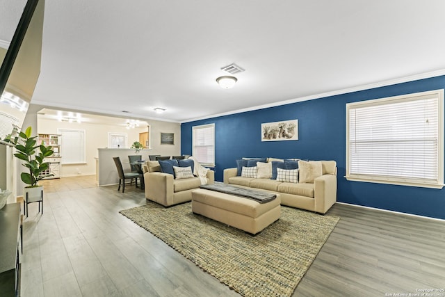 living room featuring crown molding, a chandelier, and hardwood / wood-style floors