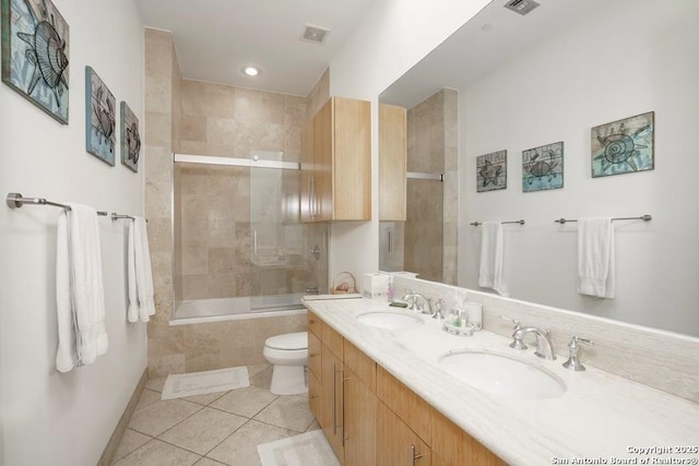 full bathroom featuring vanity, tile patterned floors, shower / bath combination with glass door, and toilet