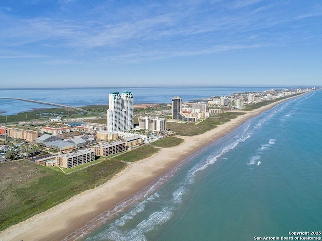 drone / aerial view featuring a beach view and a water view