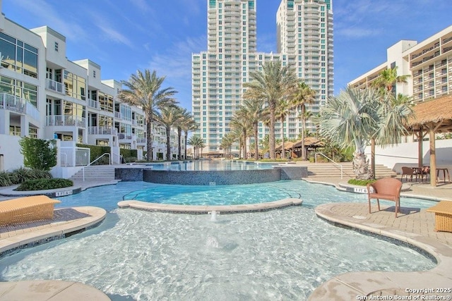 view of pool with a hot tub and pool water feature