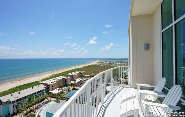 balcony featuring a water view and a beach view