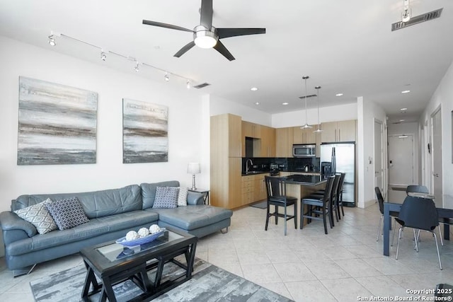 living room featuring light tile patterned floors, sink, and ceiling fan