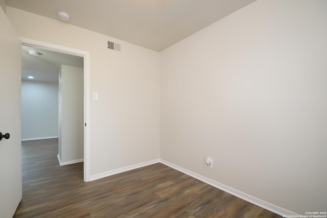 empty room with dark hardwood / wood-style flooring