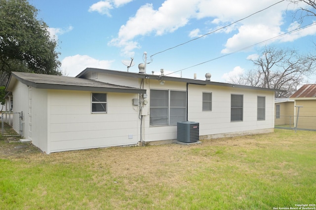 rear view of house featuring a lawn and central air condition unit