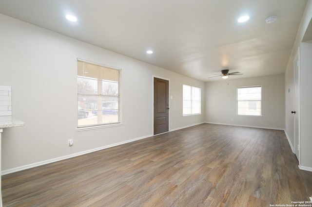 empty room featuring dark wood-type flooring and ceiling fan