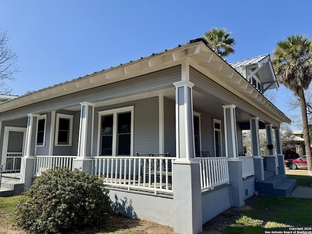 view of side of home featuring covered porch