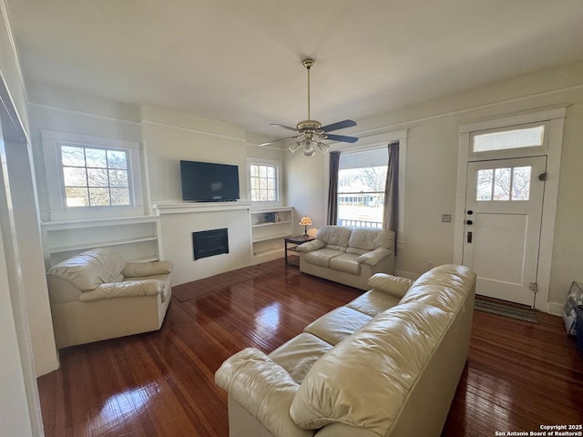 living room featuring ceiling fan and dark hardwood / wood-style floors