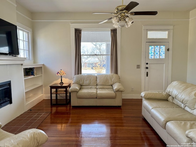 living room with ceiling fan, dark wood-type flooring, and a healthy amount of sunlight