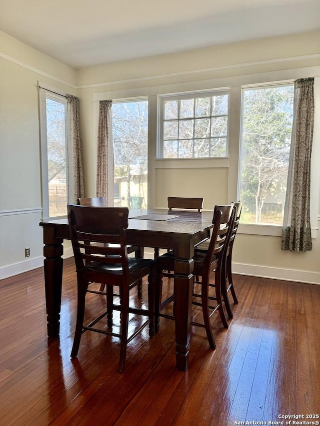 dining area with a healthy amount of sunlight and dark hardwood / wood-style flooring