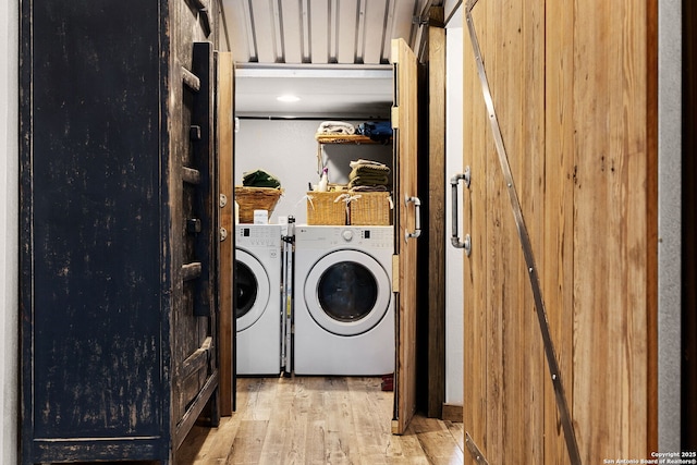 laundry area featuring separate washer and dryer and light hardwood / wood-style floors