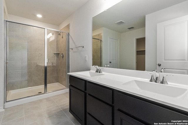 bathroom featuring tile patterned flooring, vanity, and walk in shower