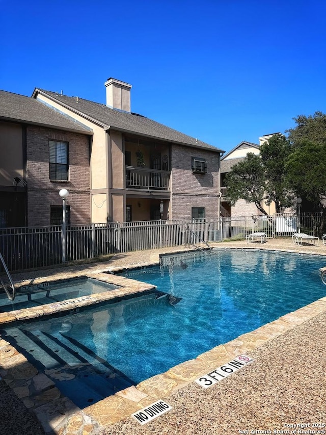 view of pool with a hot tub