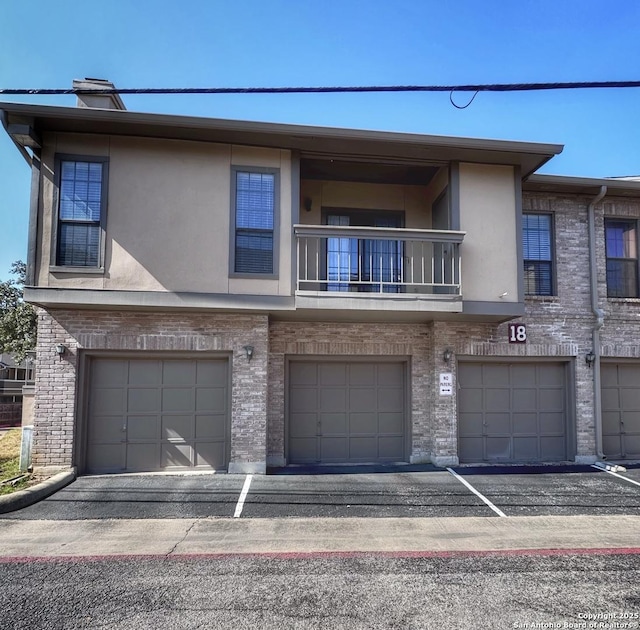 multi unit property with a balcony and a garage