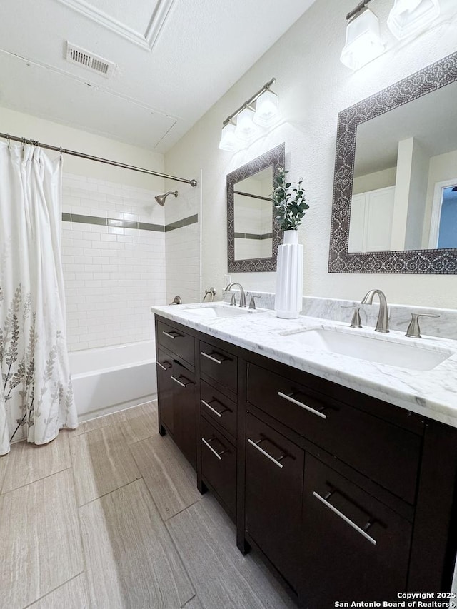 bathroom with shower / bath combo, vanity, and a textured ceiling