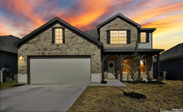 view of front of home with a garage and a lawn