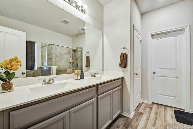 bathroom featuring hardwood / wood-style flooring, vanity, and a shower with shower door