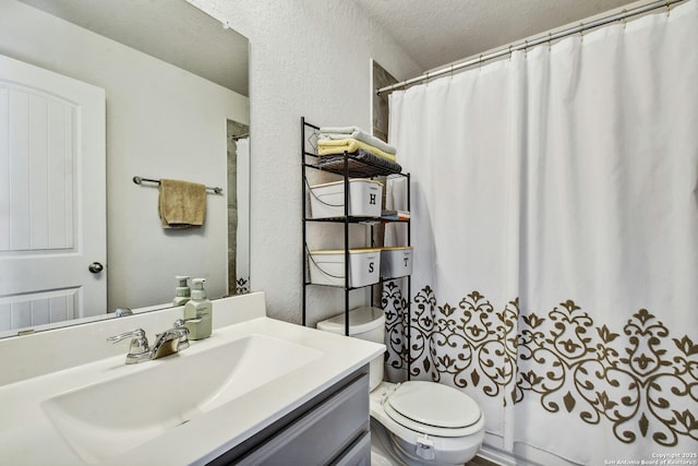 bathroom with vanity, toilet, a shower with shower curtain, and a textured ceiling