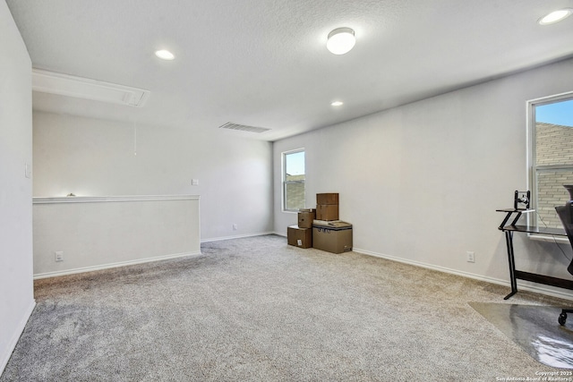 carpeted spare room with a textured ceiling