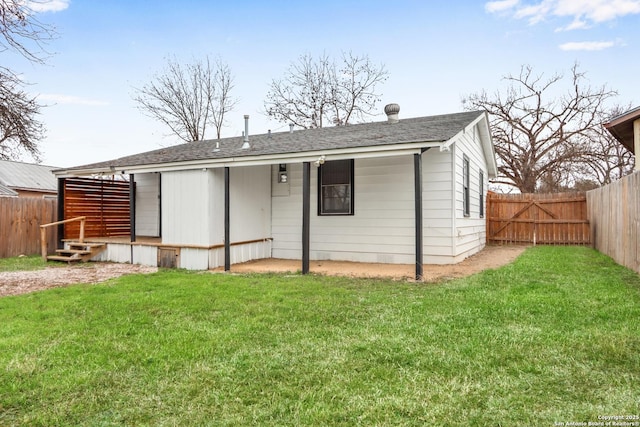 rear view of property featuring a yard