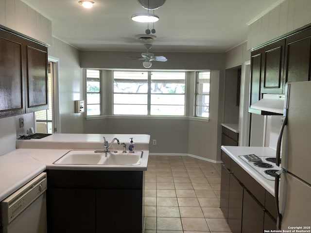 kitchen featuring white appliances, dark brown cabinetry, kitchen peninsula, and sink