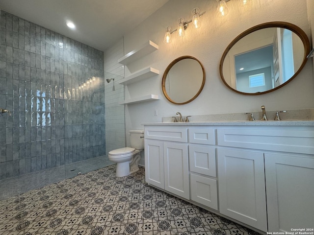 bathroom with vanity, toilet, and a tile shower